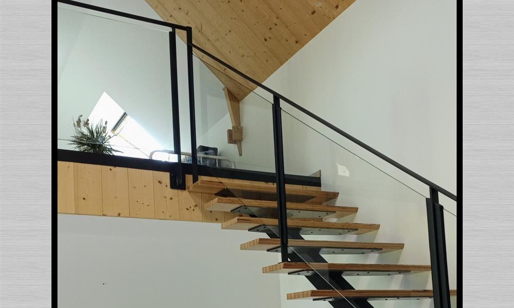 Escalier avec limon central en tube et marches bois sur platines. - 